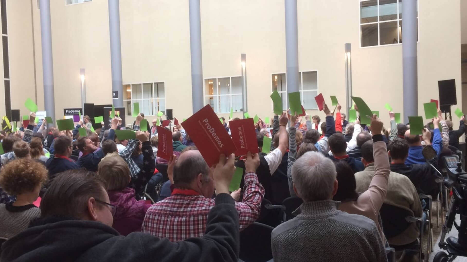 Mensen met een groene en rode kaart boven hun hoofd tijdens de Landelijke Kiezersdag 2017 in Den Haag