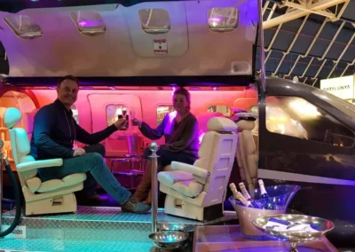 Gasten proosten met champagne in de sfeervol verlichte VIP lounge van de EX-Plane